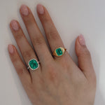 Green emerald signet ring from Take Two Jewelry next to Green emerald halo ring