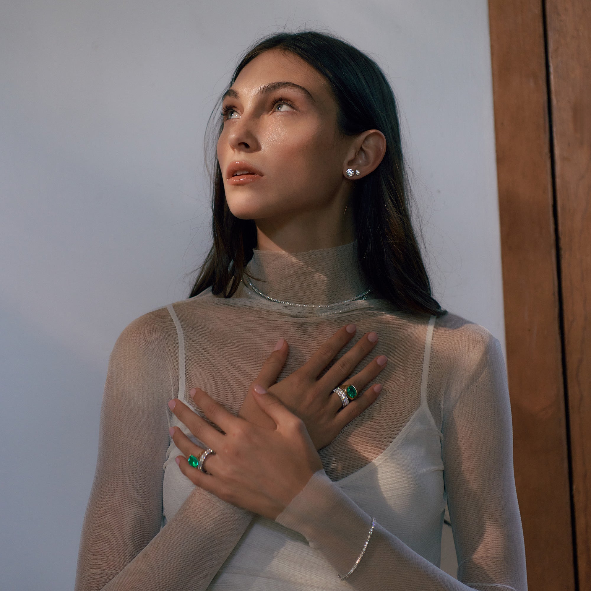 Woman wearing diamond and green emerald jewelry.