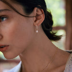 Diamond Huggies with Pear Diamond Drop earring in 14k yellow gold on model