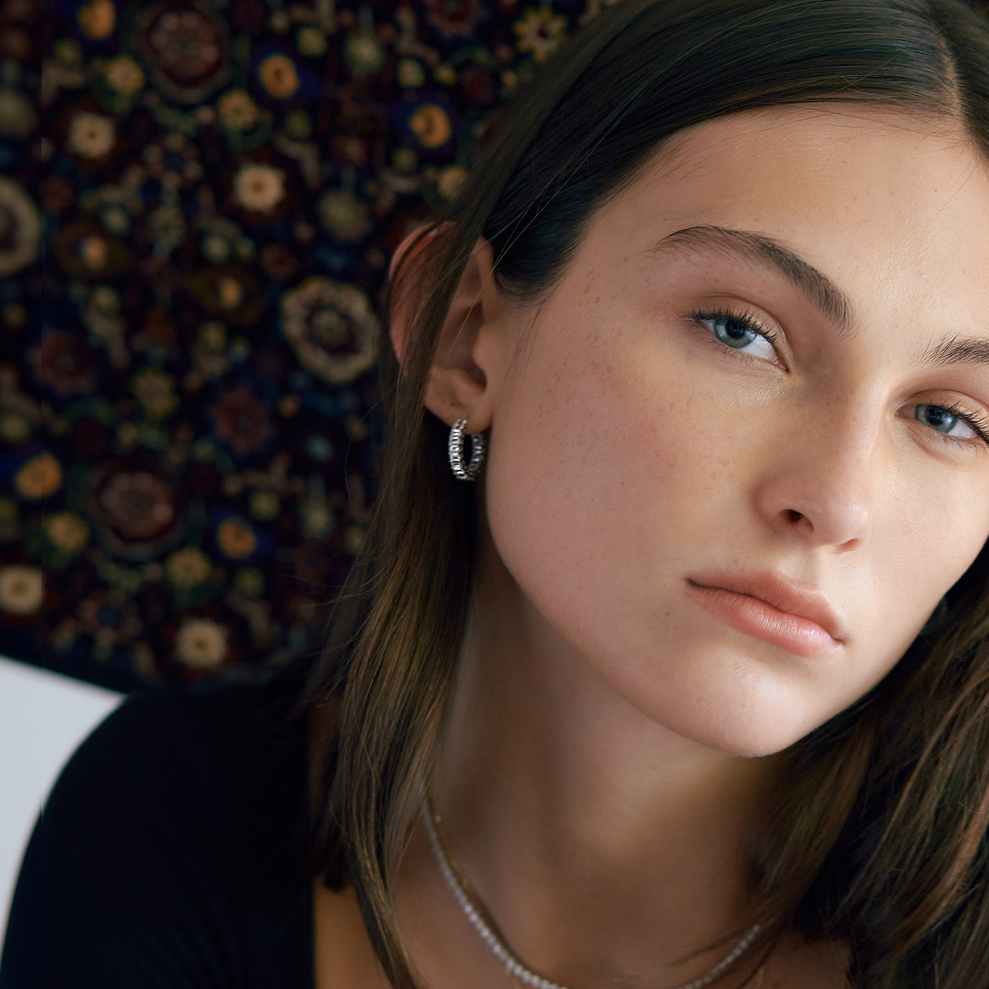 Closeup of woman wearing emerald cut diamond earrings.