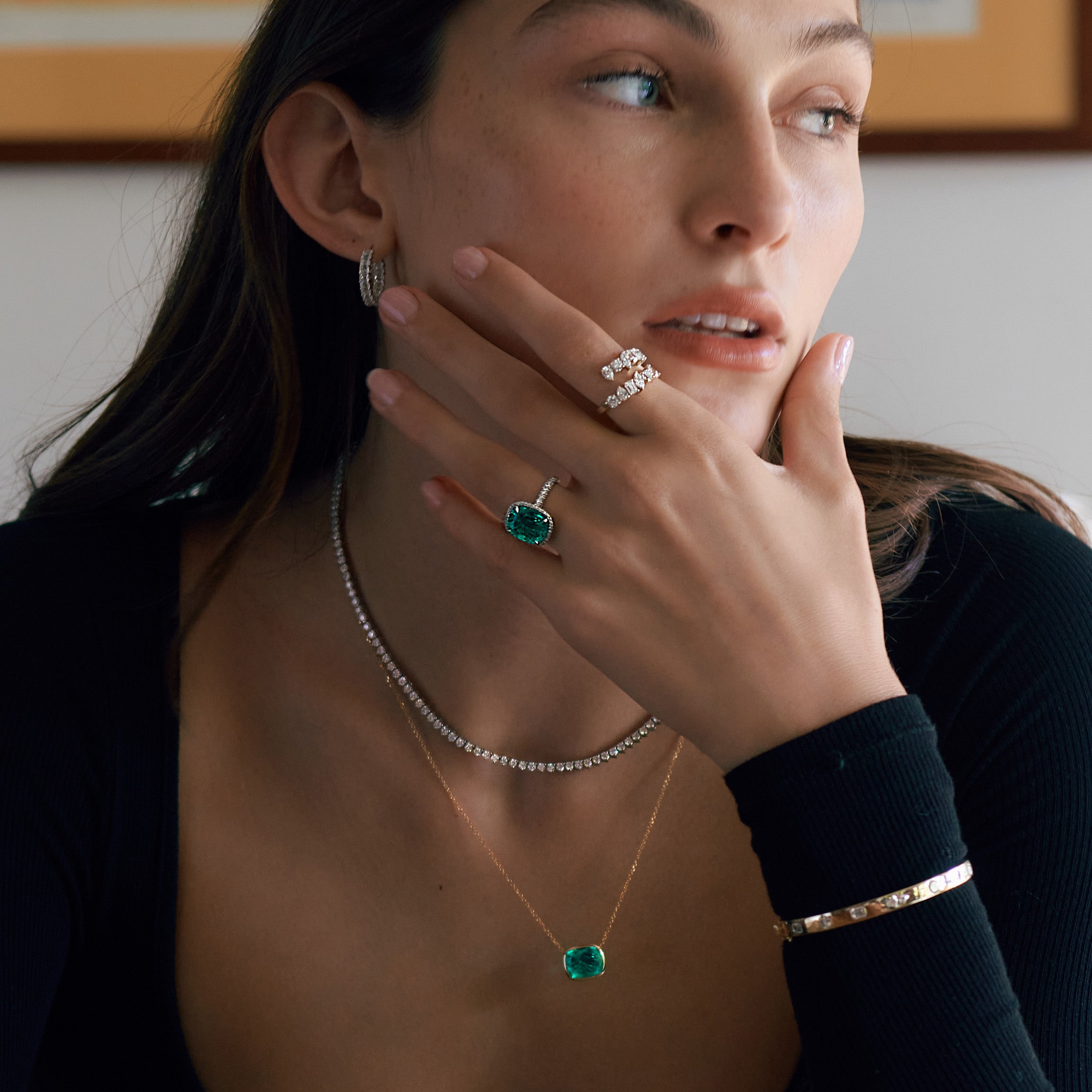 Woman wearing green emerald and diamond jewelry.