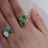 Closeup of green emerald gold rings on woman's hand.