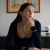 Woman wearing diamond and green emerald jewelry.